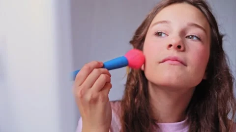 Young girl engaged in creative activity in a bright room while focusing on her Stock Footage 310506708