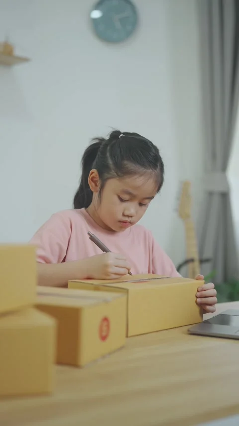 Young Girl Engaged in Creative Packaging Activity at Home with Cardboard Bo.. Stock Footage 331334495