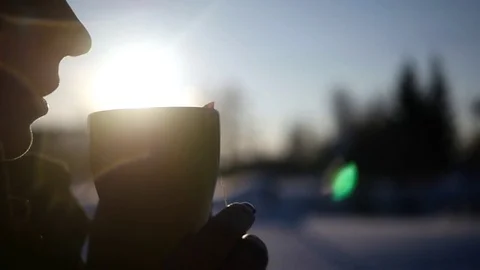A young girl enjoying a delicious hot coffee standing on the street on a Stock Footage