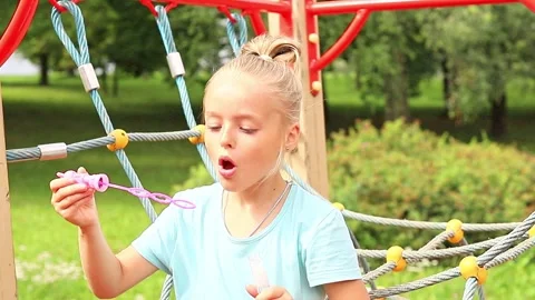 Young girl enjoys creative playtime at the playground on a sunny day 스톡 동영상 296335553