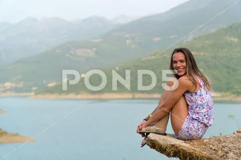 A young girl enjoys the view, sitting on a rock Stock Photos