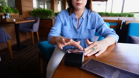 Young girl entering pin code on magnetic card reader at restaurant. Stock Footage 84088298