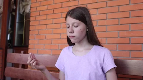 Young girl focused on project while seated in cozy indoor setting Stock Footage 297366374