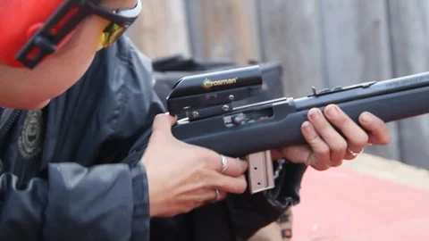 Young girl gets help with adjusting her weapon Stock Footage 114212173