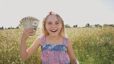 A young girl is given banknotes of dollars and she is very happy about it Stock Footage