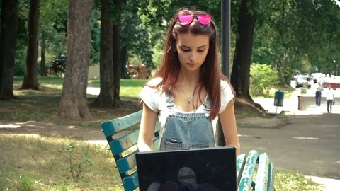 Young girl with glasses on head on laptop prints Stock Footage