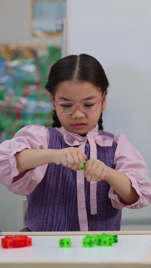 Young Girl with Glasses Learning Math with Colorful Counting Blocks Stock Footage 326083637