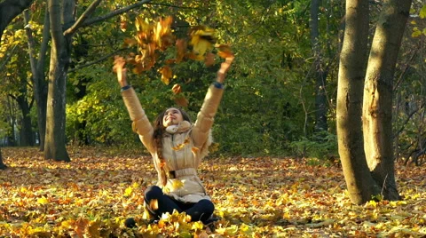 Young Girl Having Fun Throwing Yellow Leaves. Видео 56855977