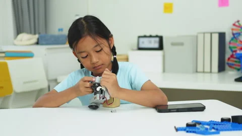 Young girl having fun working on a robot design Stock Footage 331853669