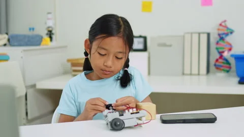 Young girl having fun working on a robot design Stock Footage 331853974