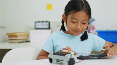 Young girl having fun working on a robot design Stock Footage 331854131