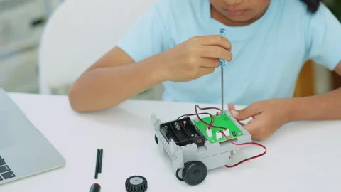 Young girl having fun working on a robot design Stock Footage 331854459