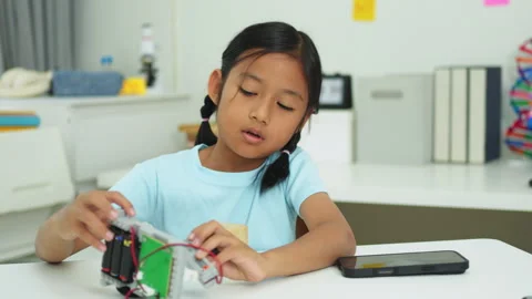 Young girl having fun working on a robot design Stock Footage 331854683