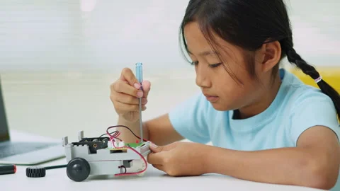Young girl having fun working on a robot design Stock Footage 331855283