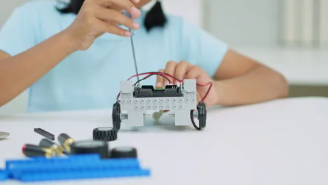 Young girl having fun working on a robot design Stock Footage 331855986