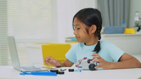 Young girl having fun working on a robot design Stock Footage 331856160