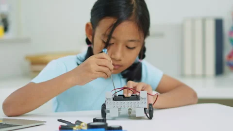 Young girl having fun working on a robot design Stock Footage 331856213