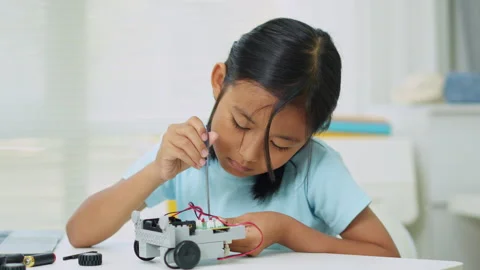 Young girl having fun working on a robot design Stock Footage 331856363