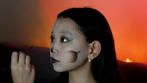Young girl is having makeup applied to her face for Halloween party. Stock Footage 319825832