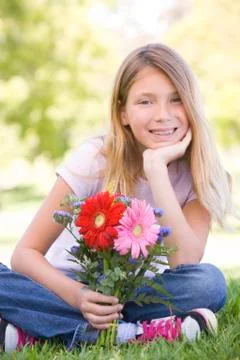 Young girl holding flowers and smiling Stock Photos