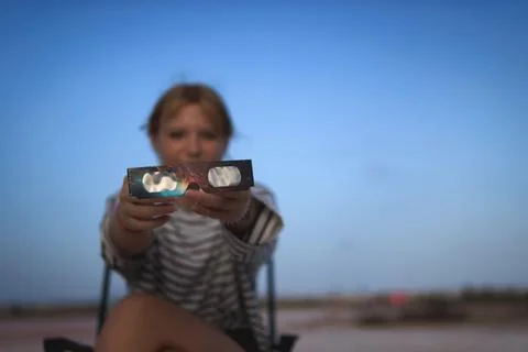 Young girl holding solar eclipse glasses. Offering eye protection for obser.. Stock Photos
