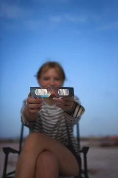 Young girl holding solar eclipse glasses, sharing a scientific tool for saf.. Stock Photos