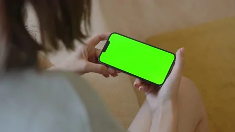Young girl at home using a mobile phone with green screen on landscape view Stock Footage 201087034