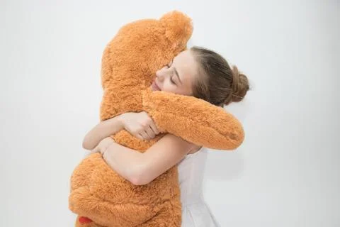 Young girl hugging a large teddy bear Stock Photos
