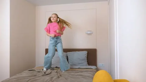 Young girl jumping on bed in different poses 库存影片 315873110