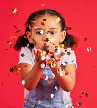 Young girl, kid blowing confetti with party and celebration, gold and glitter Stock Photos