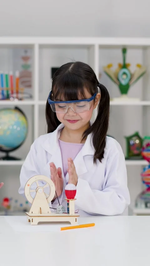 Young Girl in Lab Coat Testing Science Experiment Kit in Classroom Stock Footage 341375729