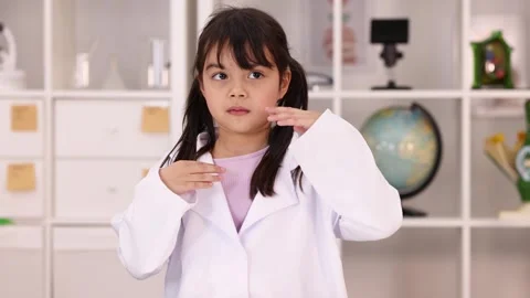 Young Girl in Lab Coat Using Sign Language in Classroom Stock Footage 342577590