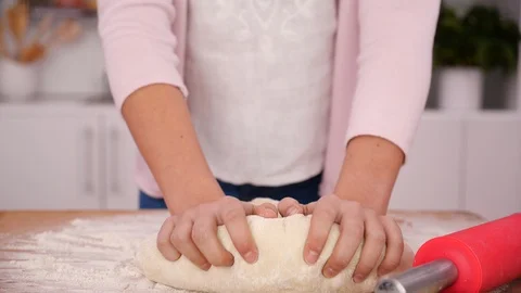 Young girl learn making bread - kneading dough on wooden board Stock Footage 114568943