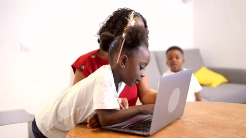Young girl learning computer skills with mother's help Stock Footage 313012113