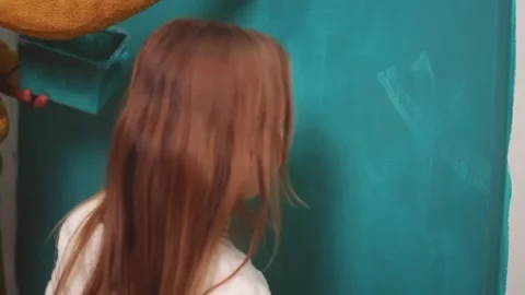 Young girl learning to paint a wall with her parent Video stock 308018992