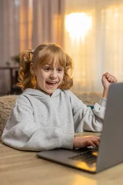 Young girl learning programming on laptop, celebrating in excitement after Stock Photos