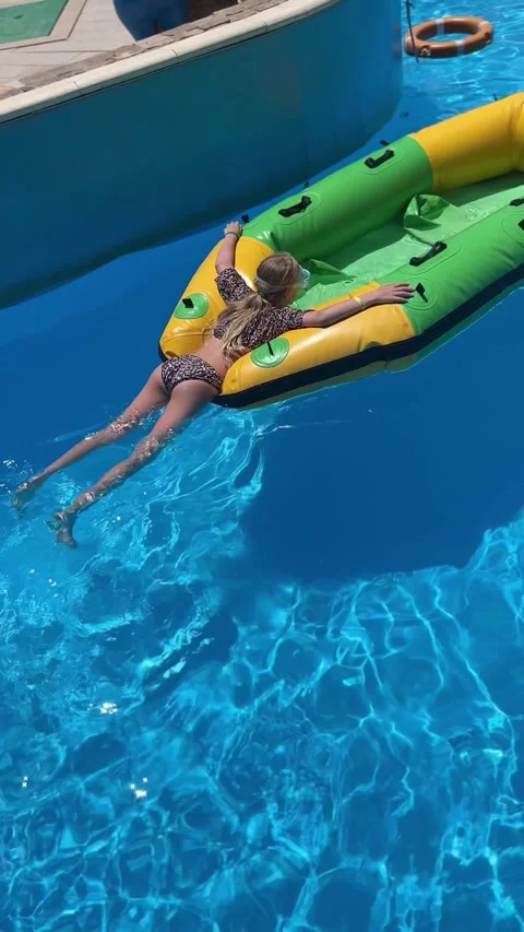 Young girl in leopard print bikini floating on an inflatable boat Stock Footage 337139269