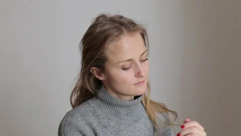 A young girl lets down her hair in a ponytail. The girl, out of fatigue, lets Stock Footage 258331643
