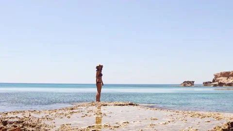 Young girl looking at camera stand on rocky formations by sea cave near Pap.. Stock-Footage 239607208