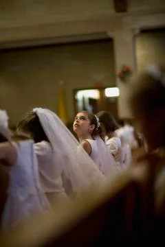 A young girl looking up at her holy communion ceremony Stock Photos