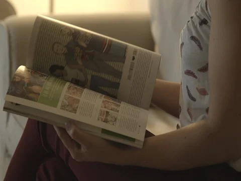 Young girl looking magazine Stock Footage