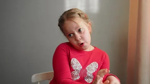Young girl looking to the side with wide eyes, showing caution and curiosity. Stock Footage 304459205