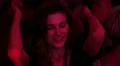 Young girl looks and winks to the camera dancing in nightclub, raises hands HD Footage