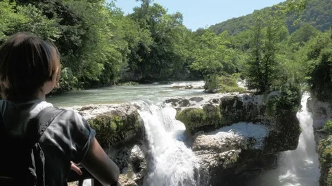 Young girl looks to the small waterfall, Georgia, Martvili Video stock 82641653