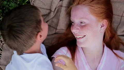 Young girl lying down plays with her brother. Video stock 166293481