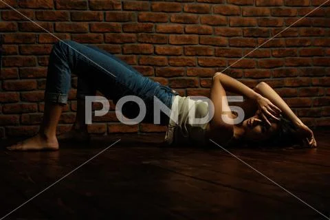 A young girl is lying on the floor. Casual style. Fashion concept. Stock Photos