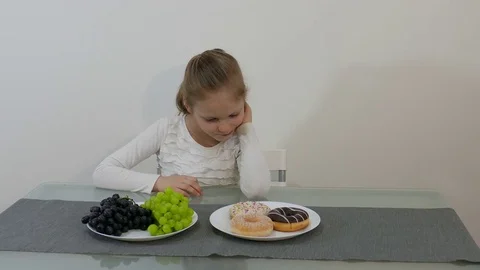 Young Girl Making Choice Between Healthy And Junk Food Stock Footage 73267275