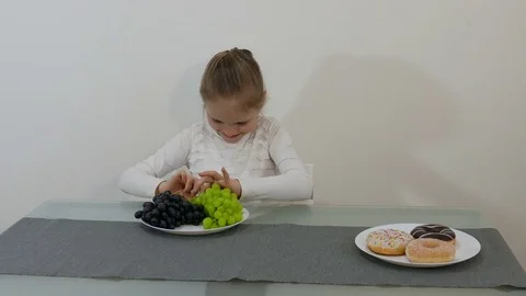 Young Girl Making Choice Between Healthy And Junk Food Stock Footage 76868614