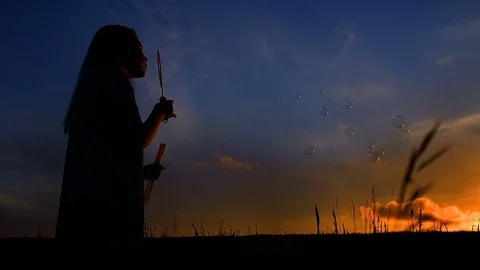 Young Girl Making Soap Bubbles In Nature, Sunset Stock Footage