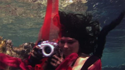 Young girl model free diver underwater in red costume of pirate in Red Sea. Stock Footage